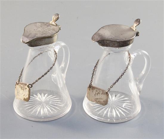 Two Edwardian silver mounted glass whisky flagons, 9.9cm.